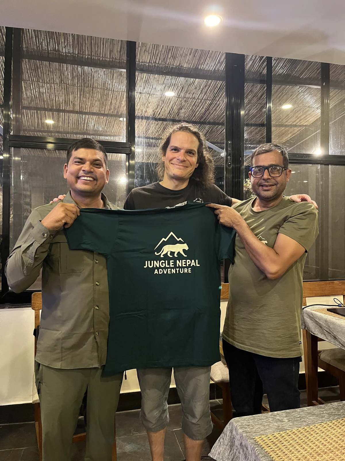 Smiling traveler with our two local trackers and the expedition shirt